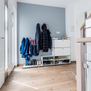 Mittelgroßer Nordischer Eingang mit Stauraum, grauer Wandfarbe, braunem Holzboden, Einzeltür, weißer Tür und braunem Boden in Frankfurt am Main