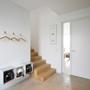 Kleiner Nordischer Eingang mit Foyer, weißer Wandfarbe, Betonboden, Einzeltür, weißer Tür und beigem Boden in München