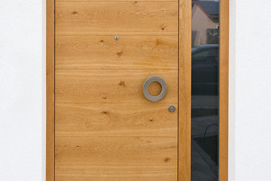 Modelo de entrada actual con paredes blancas, puerta simple y puerta de madera en tonos medios
