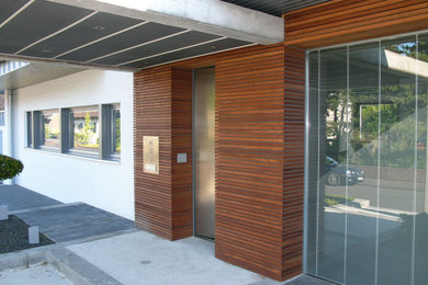 Mittelgroße Moderne Haustür mit brauner Wandfarbe, Betonboden, Einzeltür, Haustür aus Metall und grauem Boden in Düsseldorf