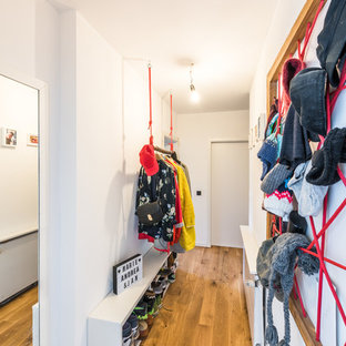 Kleiner Eklektischer Eingang mit weißer Wandfarbe, Korridor, braunem Holzboden, Einzeltür, weißer Tür und braunem Boden in Köln