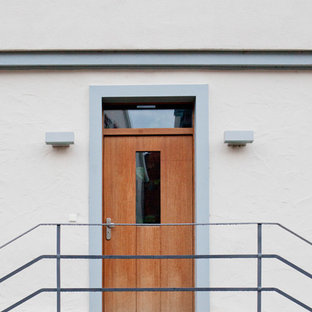 Esempio di una porta d'ingresso minimal di medie dimensioni con pareti rosse, pavimento in pietra calcarea, una porta singola e una porta in legno bruno