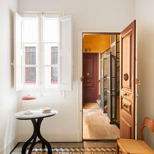 Modelo de puerta principal clásica renovada con paredes blancas, puerta simple, puerta de madera en tonos medios y suelo multicolor