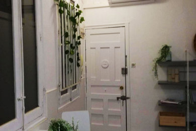Ejemplo de hall pequeño con paredes blancas y puerta simple