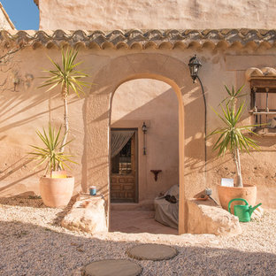 Diseño de puerta principal mediterránea con paredes beige, puerta simple y puerta de madera en tonos medios