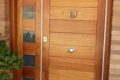 Ejemplo de entrada de estilo de casa de campo pequeña con puerta de madera en tonos medios