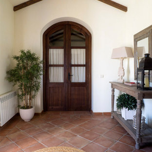 Ejemplo de vestíbulo campestre, extra grande, con paredes verdes, suelo de baldosas de terracota, puerta doble, puerta de madera oscura y suelo marrón