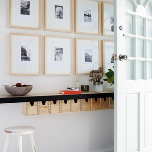 Foto de entrada clásica con paredes blancas, suelo de madera oscura, puerta simple, puerta blanca y suelo negro