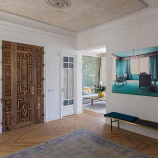 Imagen de distribuidor actual con suelo de madera en tonos medios, puerta doble, puerta de madera oscura, paredes blancas y suelo beige