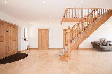 Design ideas for a large traditional foyer in Essex with white walls, ceramic flooring, a double front door, a light wood front door and brown floors.