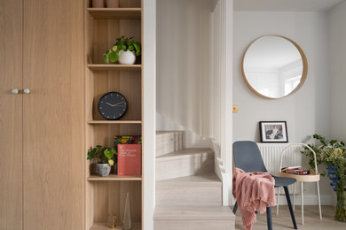 Inspiration for a scandinavian foyer in London with grey walls, light hardwood flooring and beige floors.