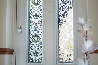 ケントにある広いサンタフェスタイルのおしゃれな玄関ドア (白い壁、カーペット敷き、白いドア) の写真