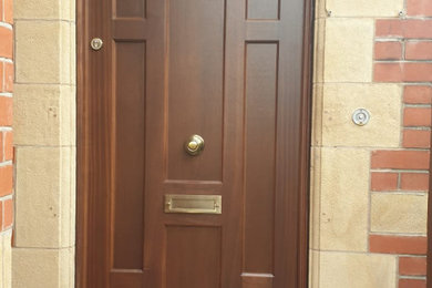 This is an example of a large classic front door in Manchester with a single front door and a dark wood front door.