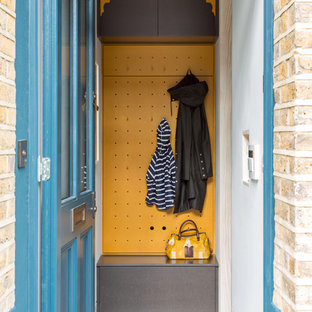Idee per un piccolo ingresso con anticamera contemporaneo con pareti gialle, una porta singola e una porta blu