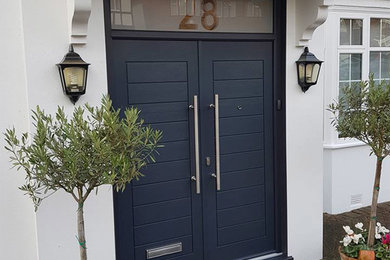 Ejemplo de puerta principal tradicional grande con paredes blancas, puerta doble y puerta azul