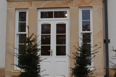 Modelo de puerta principal tradicional con puerta doble y puerta blanca