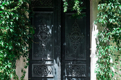 Bild på en stor vintage entré, med en dubbeldörr, beige väggar och en grön dörr