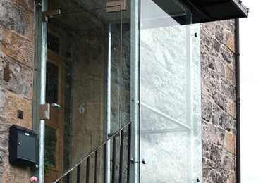 Entryway - small modern entryway idea in Glasgow with a glass front door