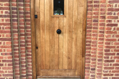 Imagen de puerta principal de estilo de casa de campo grande con puerta de madera clara