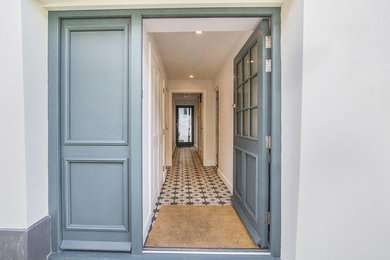 Diseño de puerta principal costera de tamaño medio con suelo de baldosas de cerámica, puerta doble, puerta azul y suelo negro