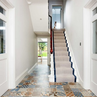 Medium sized contemporary hallway in London with white walls and multi-coloured floors.
