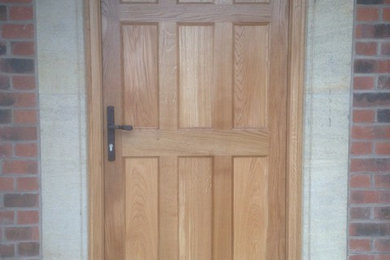 Ejemplo de entrada clásica con puerta simple y puerta de madera en tonos medios