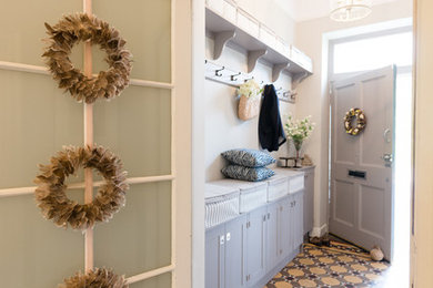 Ejemplo de vestíbulo tradicional renovado pequeño con paredes beige, suelo de baldosas de cerámica, puerta simple, puerta gris y suelo multicolor