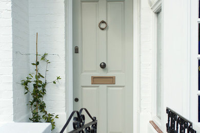 Idée de décoration pour une porte d'entrée victorienne avec une porte simple et une porte grise.