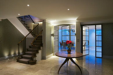 Large contemporary foyer in London with marble flooring.