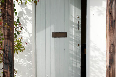 他の地域にあるラスティックスタイルのおしゃれな玄関ドア (白い壁、白いドア) の写真