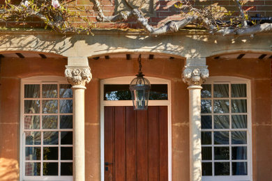 Photo of a large farmhouse front door in Surrey with a single front door and a dark wood front door.