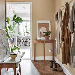 Foto på en liten nordisk entré, med beige väggar, mellanmörkt trägolv och brunt golv