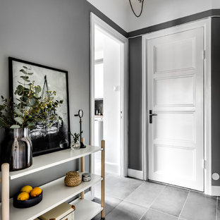 Exempel på en minimalistisk hall, med grå väggar, en enkeldörr, en vit dörr och grått golv
