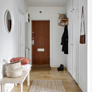 Inspiration för skandinaviska hallar, med vita väggar, ljust trägolv, en enkeldörr, mellanmörk trädörr och beiget golv