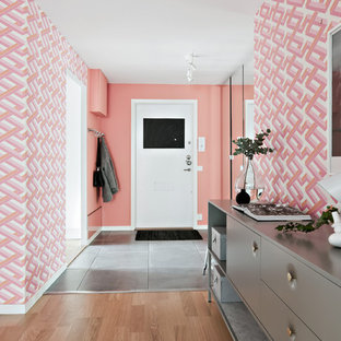 Foto på en minimalistisk entré, med vita väggar, en enkeldörr, en svart dörr och grått golv