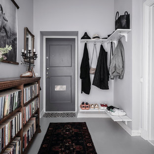 Bild på en minimalistisk foajé, med vita väggar, målat trägolv, en enkeldörr, en grå dörr och grått golv
