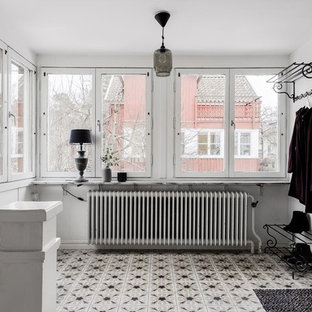 Foto på en mellanstor nordisk foajé, med vita väggar, flerfärgat golv, en enkeldörr och en vit dörr