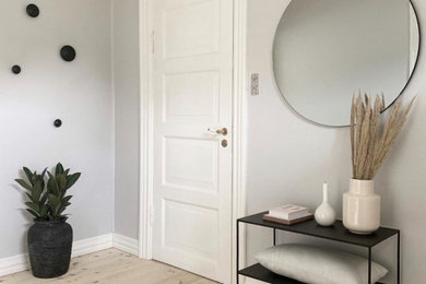 Design ideas for a scandi foyer in Aalborg with grey walls, painted wood flooring, a double front door, a white front door and white floors.