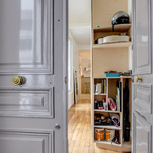 Inspiration pour une grand entrée design avec un couloir, un mur blanc, un sol en bois clair, une porte double et une porte grise.