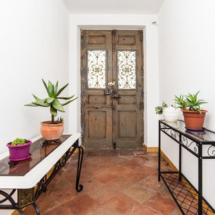 Idées déco pour une porte d'entrée méditerranéenne avec un sol en carreau de terre cuite, une porte double, une porte en bois brun et un sol rouge.
