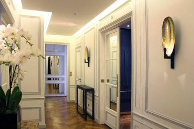 Idées déco pour un grand hall d'entrée classique avec un mur blanc, un sol en bois brun, une porte simple et une porte blanche.