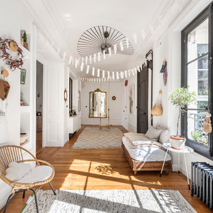 Idée de décoration pour une entrée bohème avec un mur blanc, un sol en bois brun, un couloir, une porte simple et une porte noire.