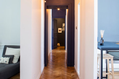 Idées déco pour une entrée contemporaine de taille moyenne avec un couloir, un mur blanc, un sol en bois brun et une porte verte.