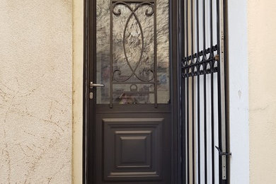 Cette image montre une entrée traditionnelle avec une porte simple.