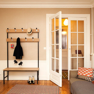 Réalisation d'une entrée nordique de taille moyenne avec un mur orange, un sol en bois clair et un vestiaire.