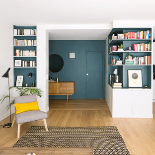Réalisation d'un hall d'entrée design de taille moyenne avec un mur bleu, un sol en bois clair, une porte simple, une porte bleue et un sol beige.