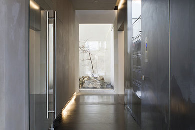 Idées déco pour un hall d'entrée contemporain avec un mur multicolore, sol en béton ciré et une porte en verre.