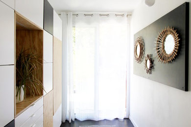 Aménagement d'un petit hall d'entrée contemporain avec un mur blanc, un sol en carrelage de céramique et une porte blanche.