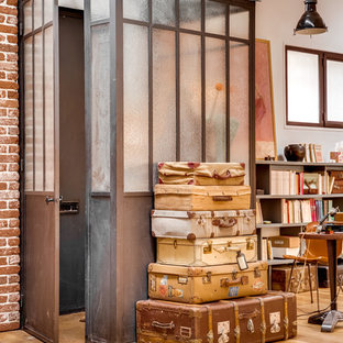 Inspiration pour un vestibule urbain de taille moyenne avec une porte simple, une porte métallisée, un sol beige et un sol en bois clair.