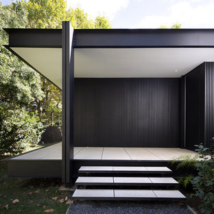Cette photo montre une porte d'entrée moderne de taille moyenne avec un mur noir, un sol en carrelage de céramique, une porte simple, une porte noire et un sol blanc.